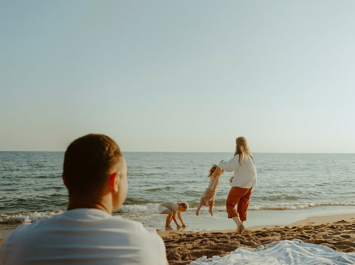 Family playing on a sunny beach, enjoying summer activities near the ocean.
